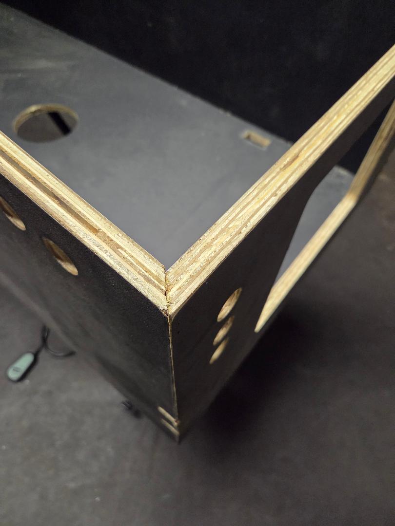 Corner of a black and wood ultra widebody flat pack