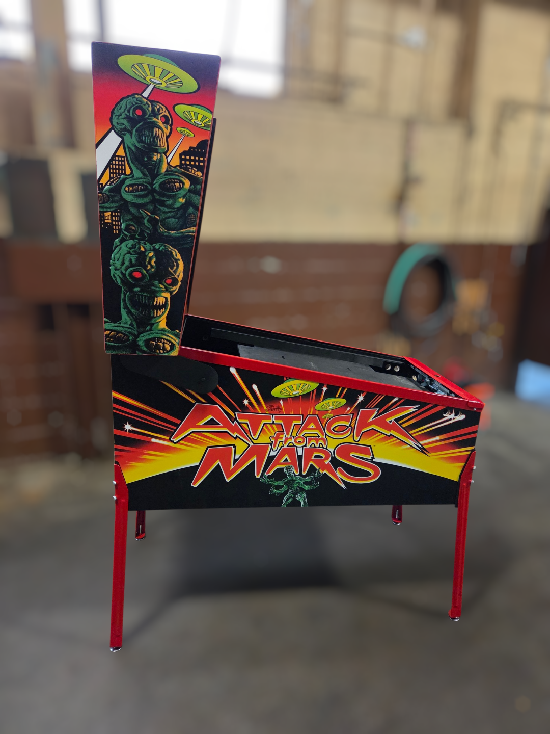 virtual Pinball machine with 'Attack from Mars' design in a room setting